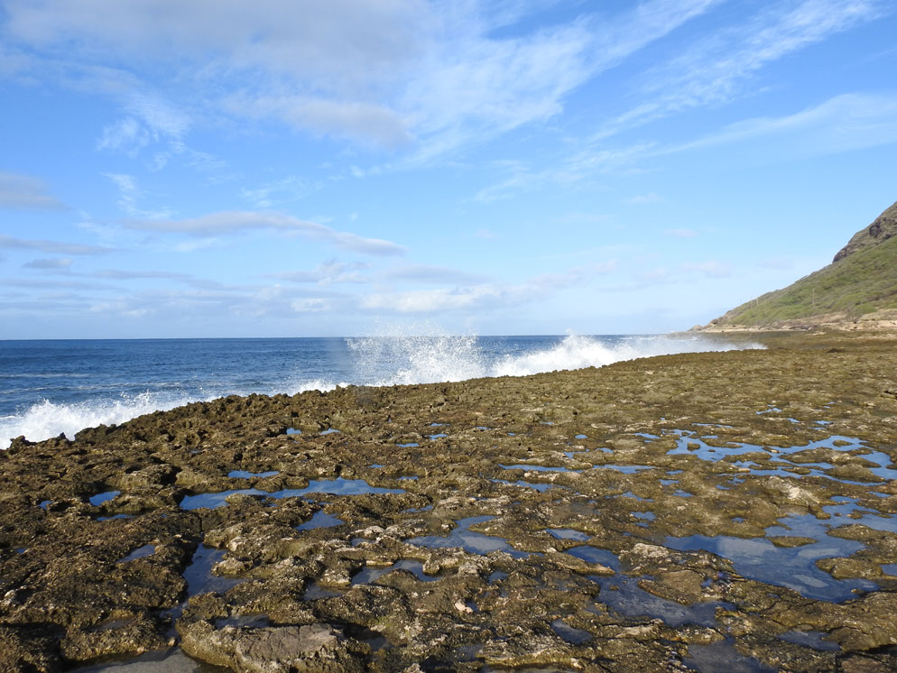 The sky is no longer the limit Zoom slider photo of a rocky shoreline with waves hitting it and a blue sky, wide shot