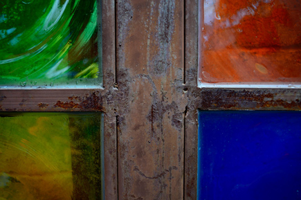 Translate your passion into photographs at Nikon School Photo of a painted window, with each pane another color: red, blue, yellow and green.