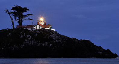 Spice up your stories, learn how at Nikon School Photo of a lighthouse on a hill, in low light at night