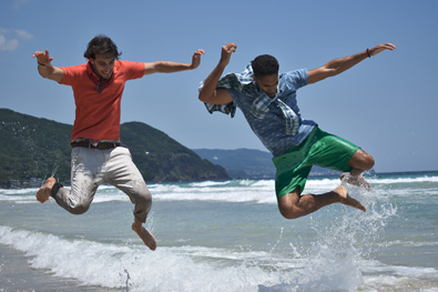 D3400 photo of two guys jumping over waves in the ocean