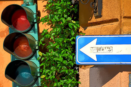 Nikon D5600 DSLR photo of a street sign and streetlight against an orange brick wall