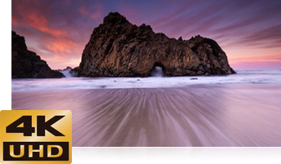 D500 photo of a low light photo of a rocky ocean shoreline with the 4K UHD logo inset