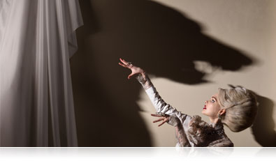 Photo of a model with a shadow of a wolf on the wall showing creativity