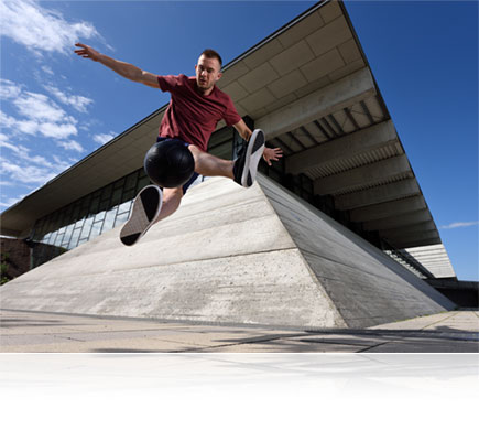 Nikon D750 photo of a male parkour athlete in mid air jump
