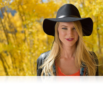 D5500 photo of a blonde woman in a black cowboy hat with trees in the background