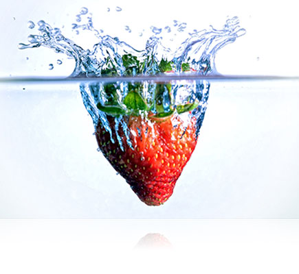 Fotografia de um morango caindo e espirrando água, feita usando a lente AF-S DX NIKKOR 18-105mm f/3.5-5.6G ED VR