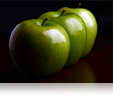 Fotografia de três maçãs verdes feita com a lente AF-S DX NIKKOR 18-105mm f/3.5-5.6G ED VR