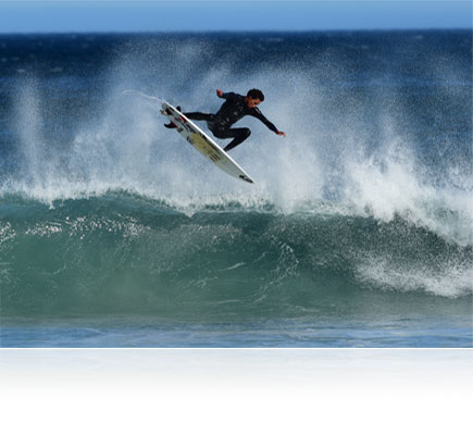 Photo of a surfer in air over a crashing wave, shot with the AF-S NIKKOR 500mm f/4E FL ED VR lens