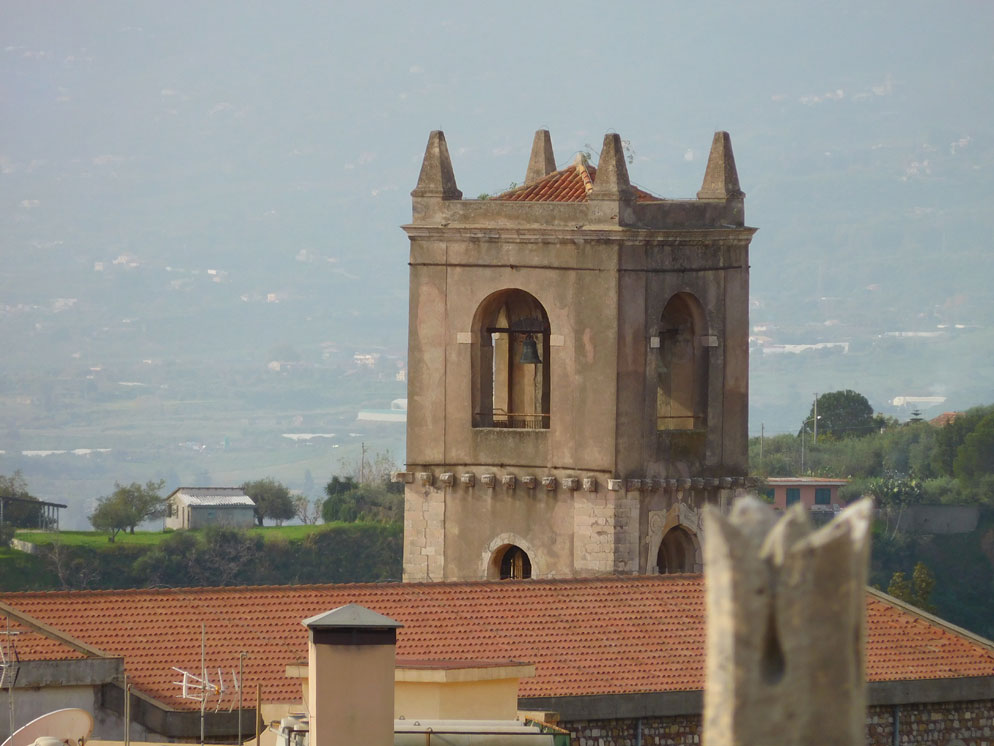 Zoom slider photo of a village, zoomed all the way in to see a tower and rooftop
