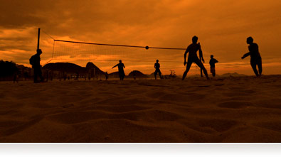 Photo of beach volleyball players at sunset
