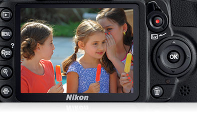 Close up photo of the D3100's LCD with the buttons on the camera showing, with an image of three girls eating ice pops on the LCD