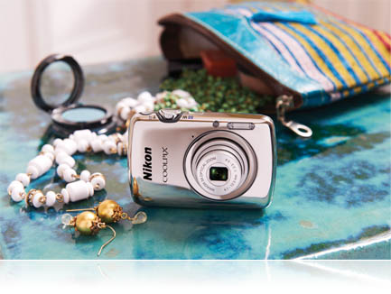 The S01 is the smallest COOLPIX ever photo of the COOLPIX S01 with contents of an open purse on a table