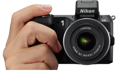 photo of a hand holding the Nikon 1 V2 with finger on the shutter button