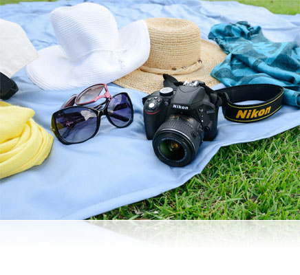 Photo of the Nikon D3300 and hats, scarf and sunglasses on a blanket on the grass
