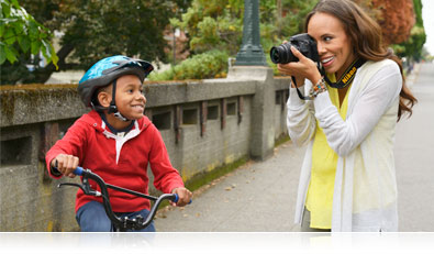 D3300 photo of a woman photographing her son on a bicycle
