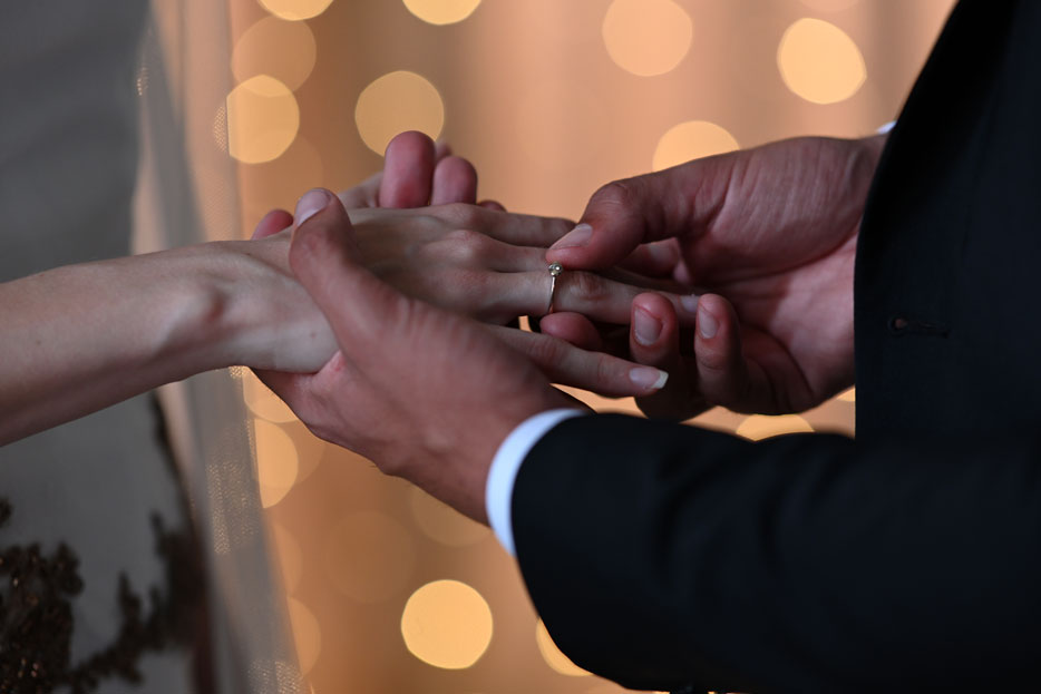 close up photo of a groom putting a wedding ring on a bride, taken with the Z 7 and F-mount NIKKOR lens using the Mount Adapter FTZ