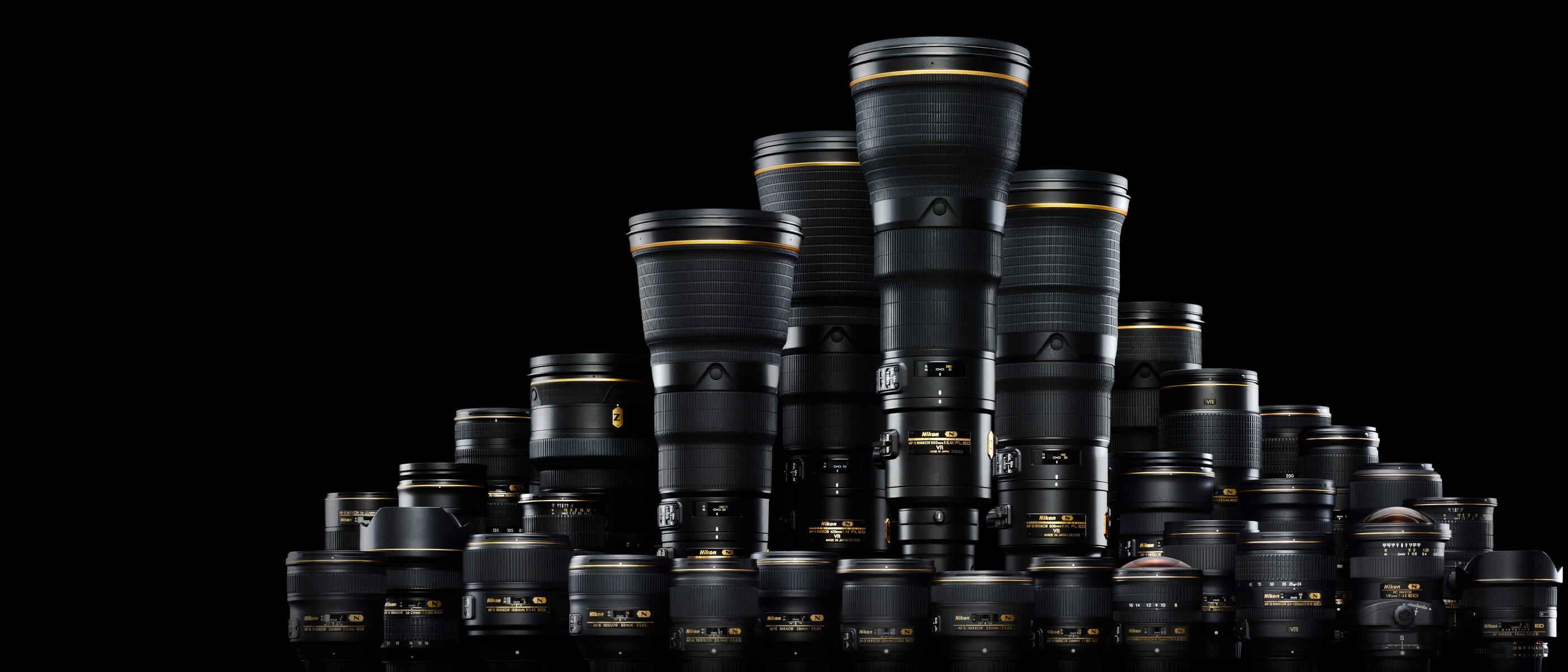 Family photo of a large grouping of F mount NIKKOR lenses