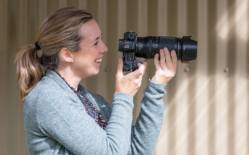 photo of a woman using a camera and NIKKOR Z 70-180mm f/2.8 lens