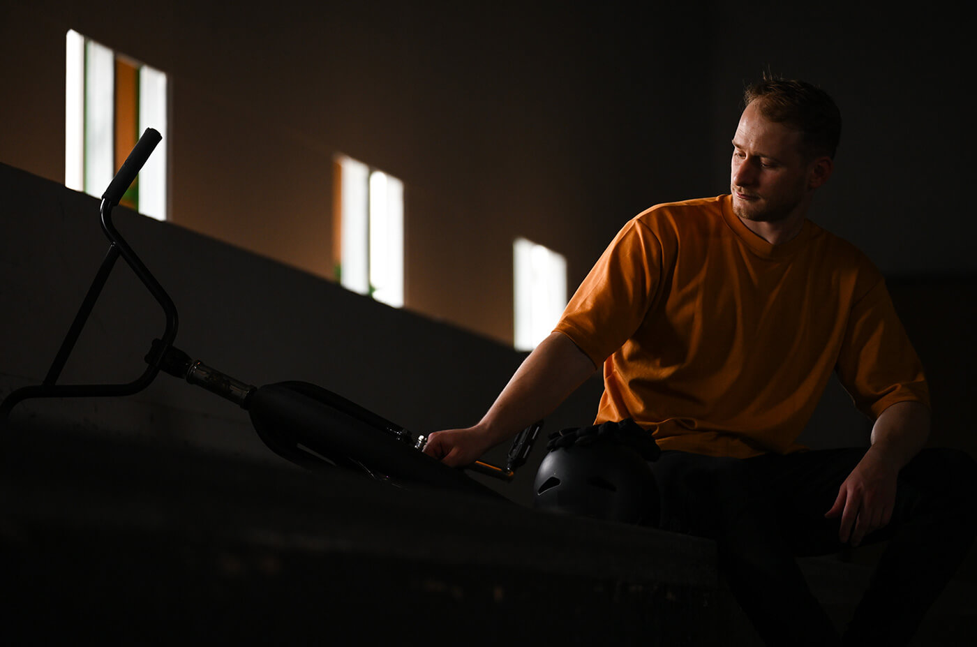 photo of a guy with a bicycle indoors in low light, taken with the NIKKOR Z 70-180mm f/2.8 lens