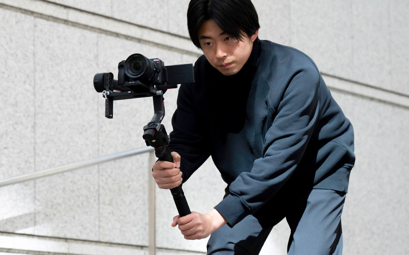 photo of a man holding a camera and NIKKOR Z DX 12-28mm f/3.5-5.6 PZ VR lens on a gimbal