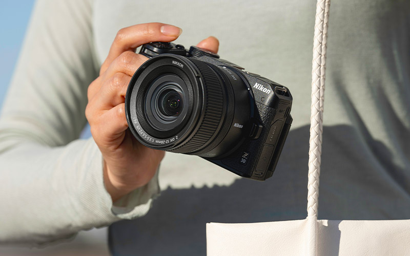 photo of a person holding the Z 30 and NIKKOR Z DX 12-28mm f/3.5-5.6 PZ VR lens