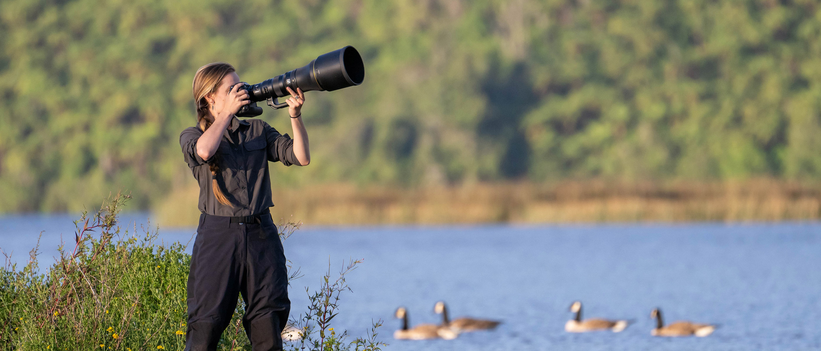Photo of a woman dressed in black photographing outdoors with the NIKKOR Z 800mm f/6.3 VR S lens 