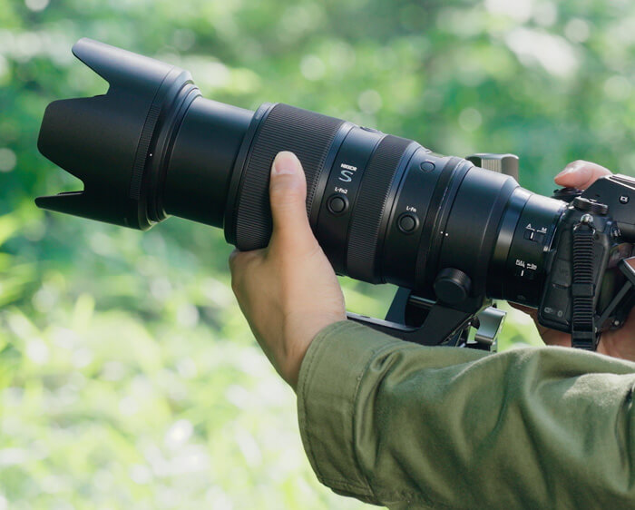 Photo d'un appareil photo Z avec Nikkor Z 100-400 mm f / 4,5-5,6 VR S Lens à la main