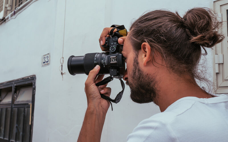 photo of a man with a camera and NIKKOR Z DX 18-140mm f/3.5-6.3 VR lens