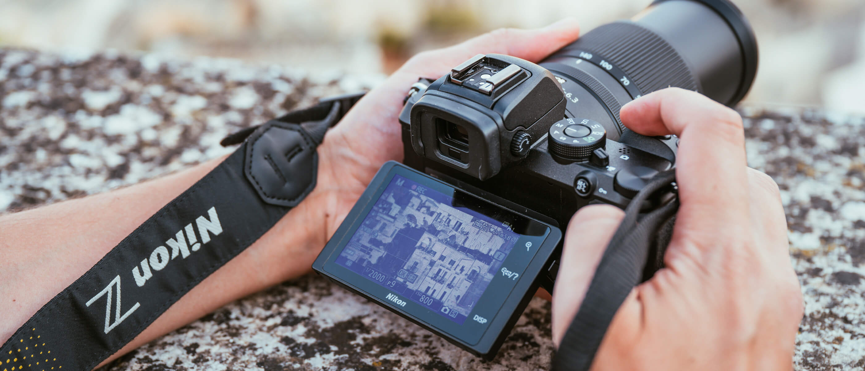 photo of a person holding a Z camera and NIKKOR Z DX 18-140mm f/3.5-6.3 VR lens