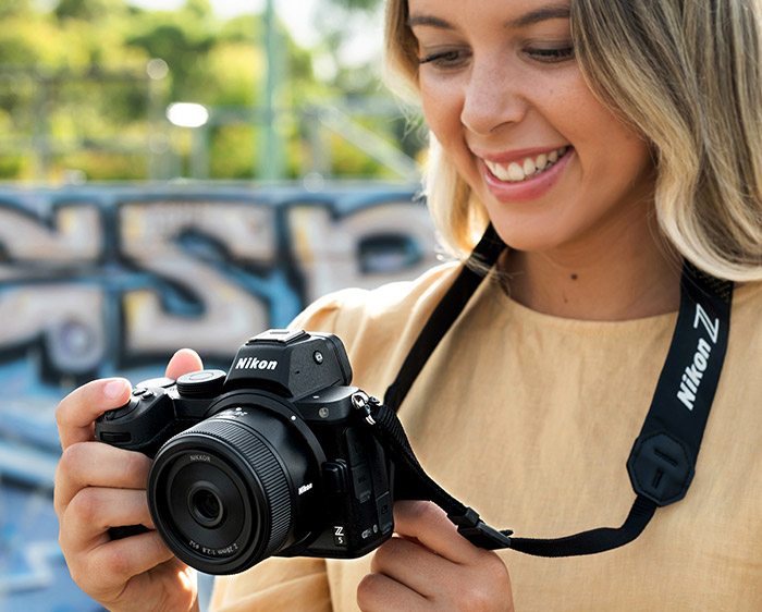 Photo d'une femme avec un appareil photo Z et de l'objectif Nikkor Z 28 mm f / 2,8