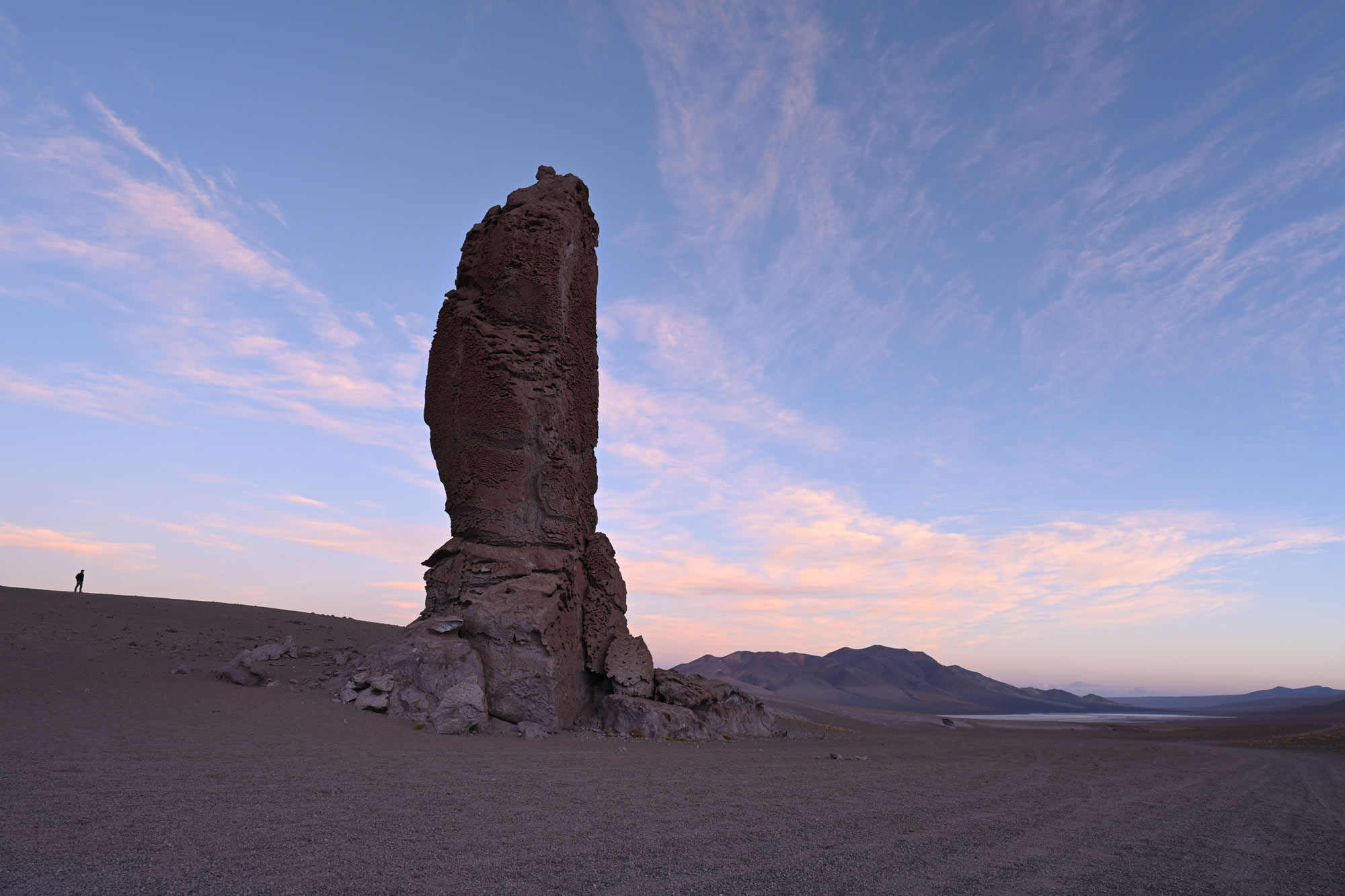 Foto di un affioramento roccioso nel deserto, con una figura in lontananza, scattata con il NIKKOR Z 20mm f/1.8 S