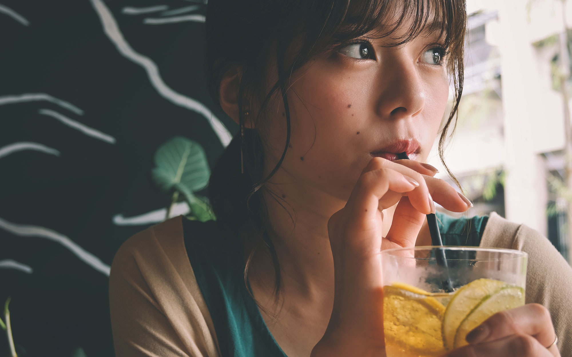 Photo of a woman drinking from a glass through a straw, taken with the Z 50 and NIKKOR Z DX 16-50mm f/3.5-6.3 VR lens