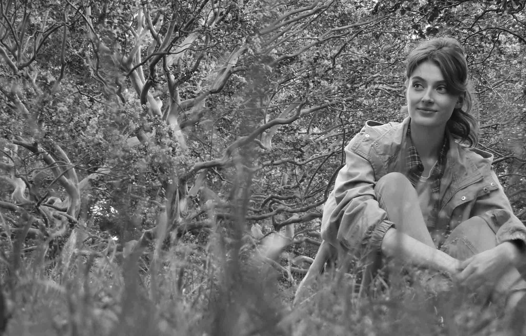 B&W photo of a woman among the trees, shot with the Nikon COOLPIX A1000