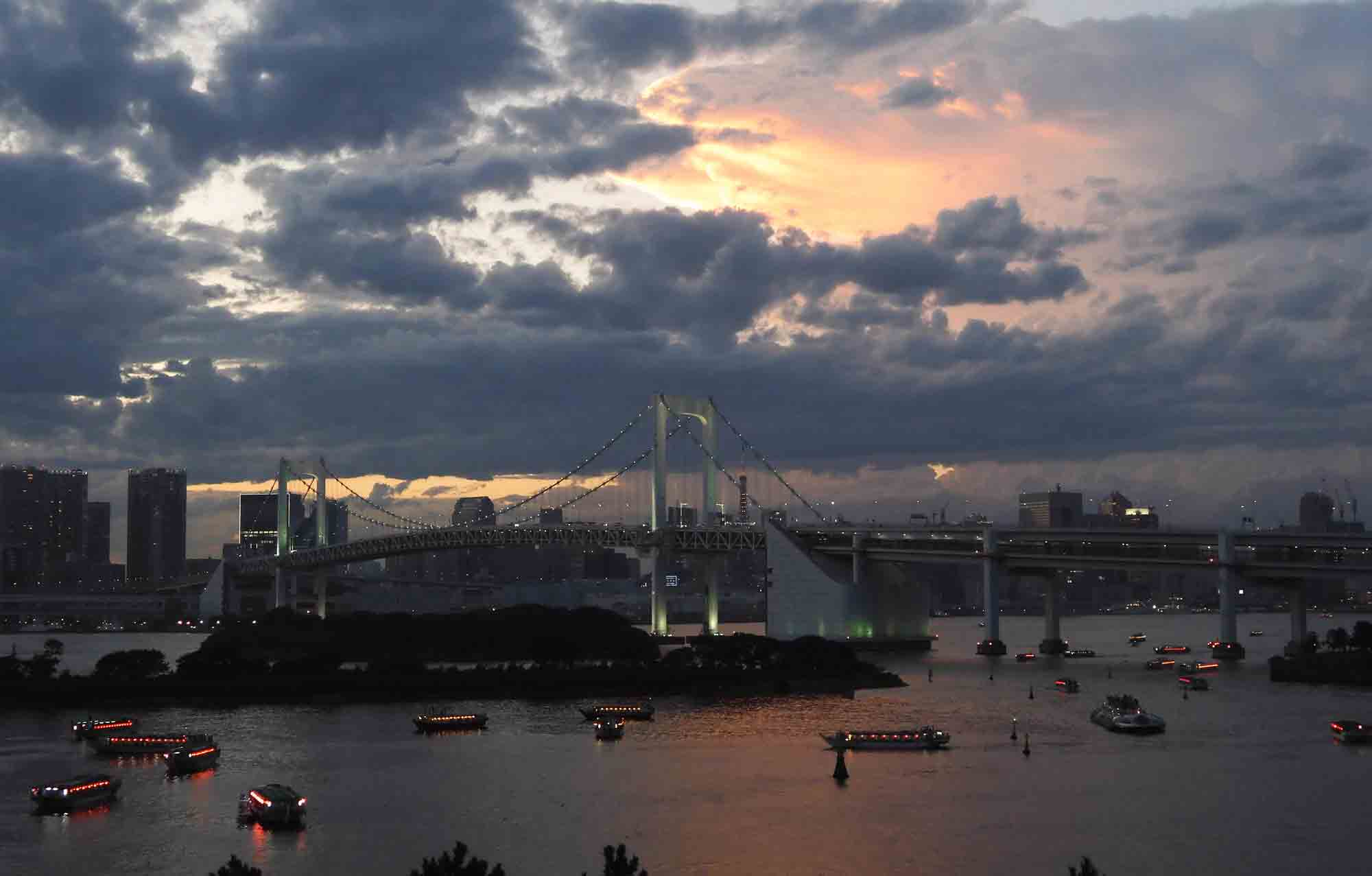 Nikon COOLPIX A1000 photo of a cityscape at sunset with a bridge and boats lit up