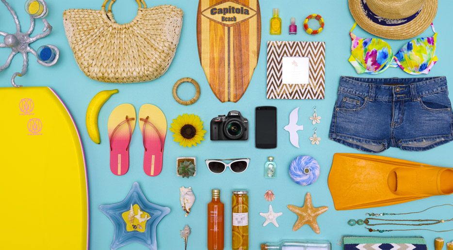 Photo of summer fun items, including beach toys and the Nikon D3400 and a smartphone showing the small size of the camera