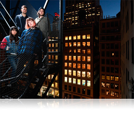 D500 Photo Of Four People On A Fire Escape With A City Night Scene In The Background