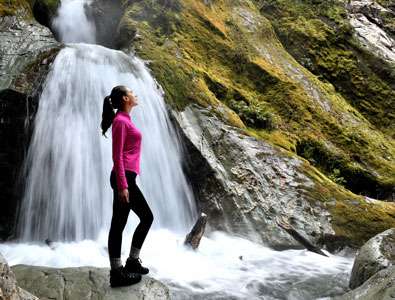 Photo of a woman with a waterfall in the background