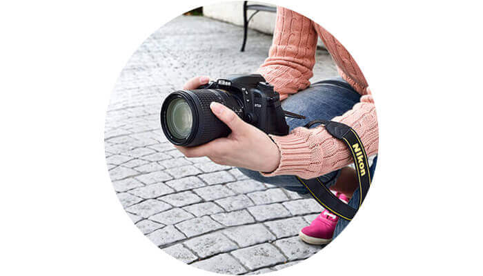 Photo of a woman kneeling down holding the D7500 in her hands