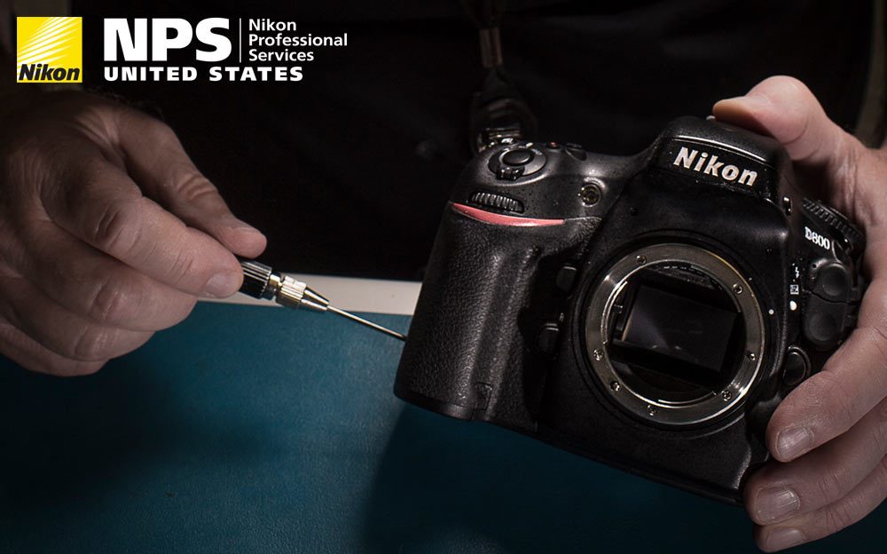 Photo of a technician's hands working on a Nikon DSLR