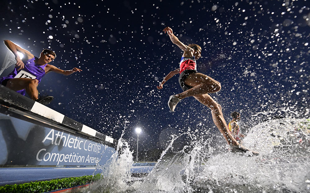 D6 DSLR photo of runners jumping over water splashing