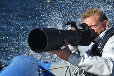 Photo of a photographer shooting with the D6 DSLR and long telephoto lens from a boat