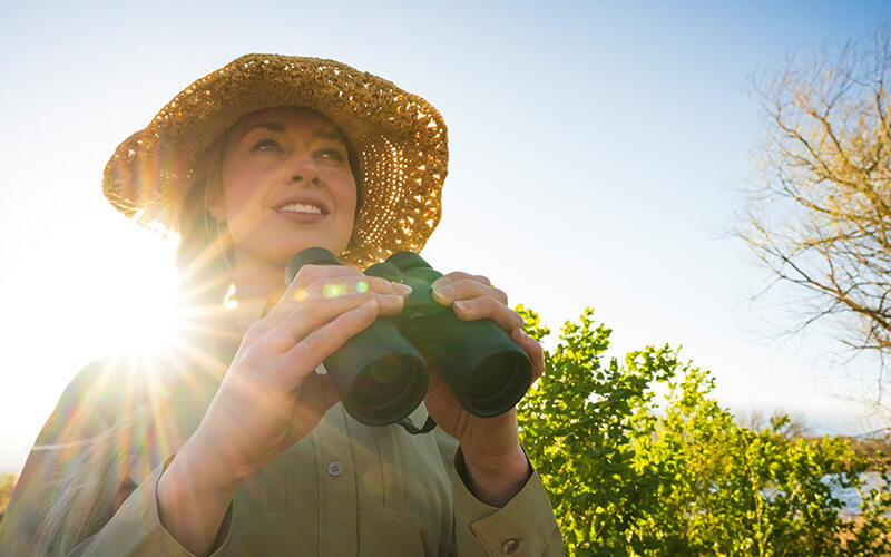 photo of a woman in a hat, holding a pair of PROSTAFF P3 8X42 binoculars