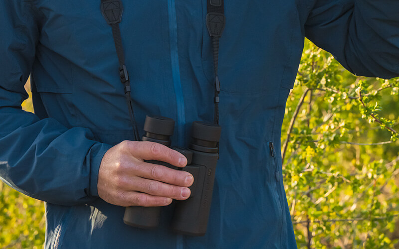 photo of a man in a blue jacket holding a pair of PROSTAFF P3 8X42 binoculars