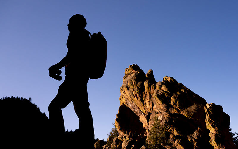 silhouette of a hiker with binoculars in the hills
