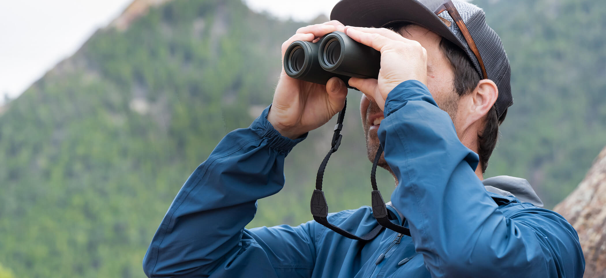 Photo of a man looking through a pair of PROSTAFF P7 8X30 binoculars