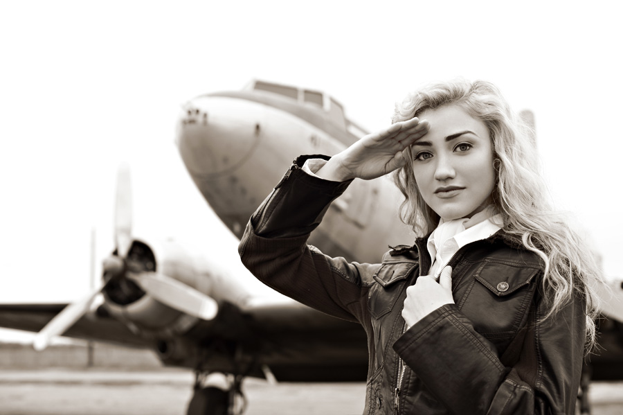 Photo of a model dressed as a pilot in front of an old plane in sepia tone, shot using the AF-S NIKKOR 50mm f/1.4G lens