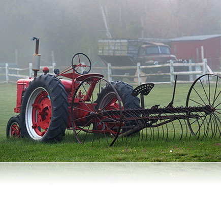 Photo shot with the AF VR Zoom-NIKKOR 80-400mm f/4.5-5.6D ED lens of farm equipment on a lawn in the fog