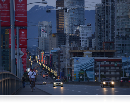 photo of a city street at dusk with mountains in the background